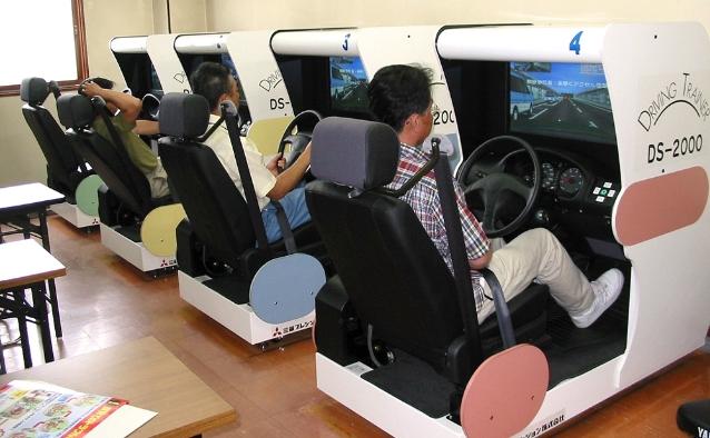 ドライビングシミュレーターで練習する受講者たち