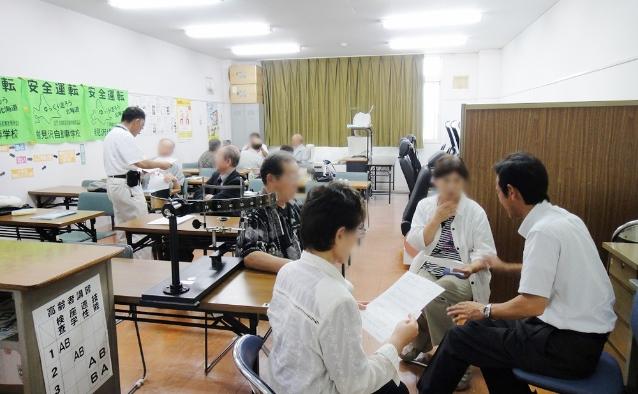 教習所の教室で個別指導を受ける高齢者講習の様子