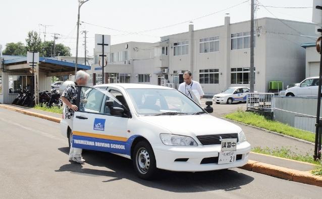 白い教習車で高齢者講習を受ける受講者の様子