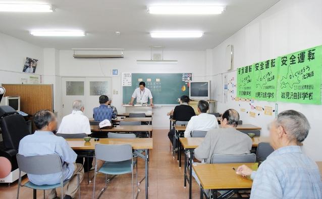 教習所の教室で講師の話を聞く高齢者講習の受講者たち